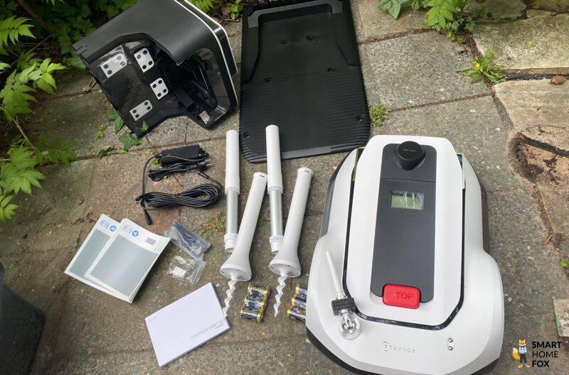 Die zwei im Lieferumfang befindlichen Navigationsbaken des ECOVACS Goat G1-800 Mähroboters liegen auf dem Boden.